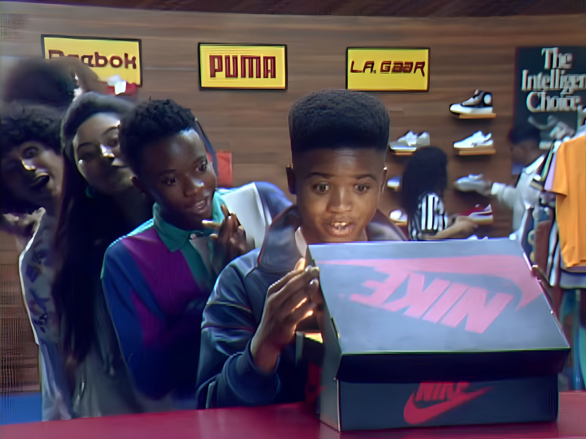 Excited boys looking inside a red and black Nike shoebox.
