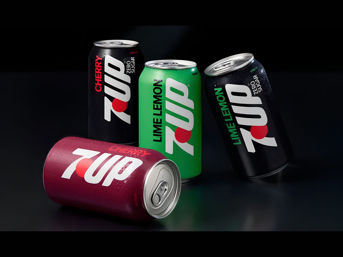 Four redesigned 7UP flavor cans covered in water droplets.