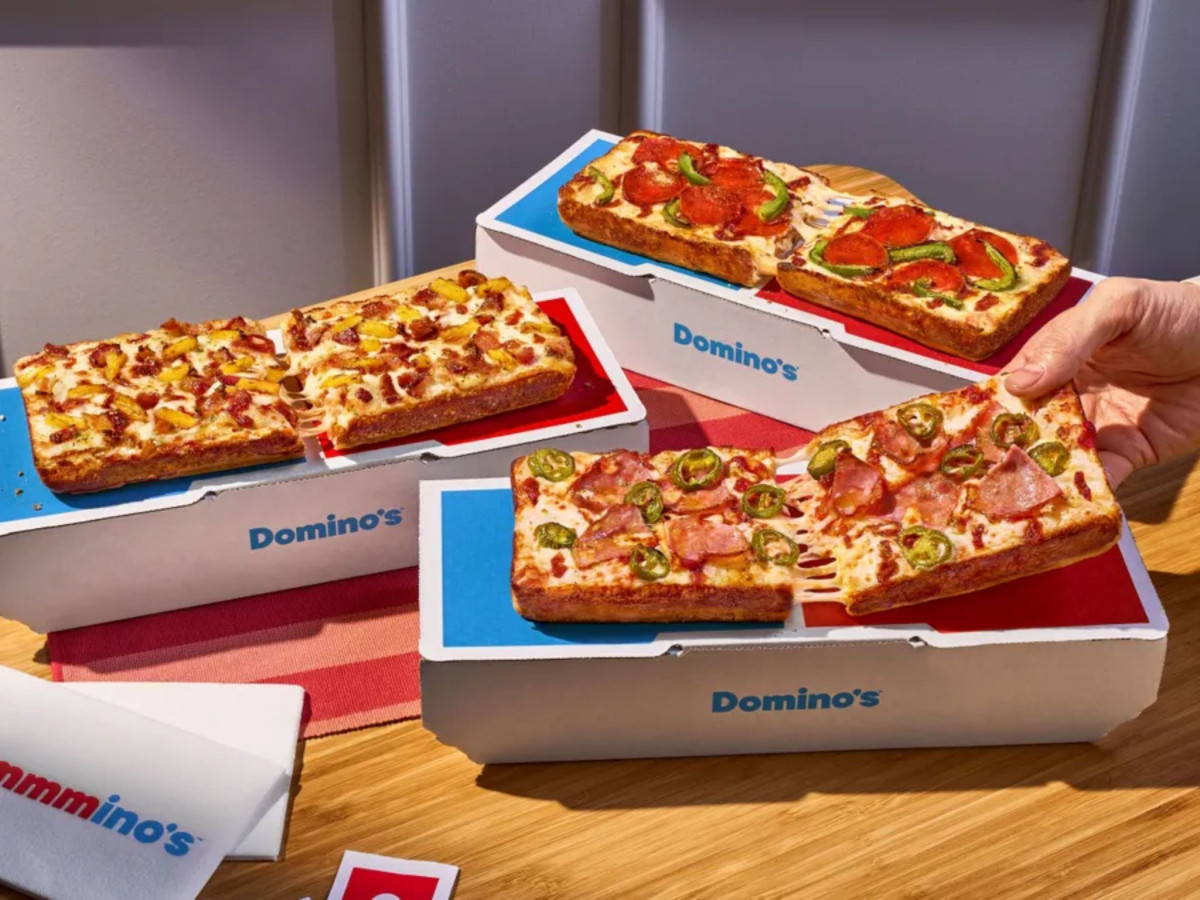 Three rectangular pizzas in open custom Domino's boxes.
