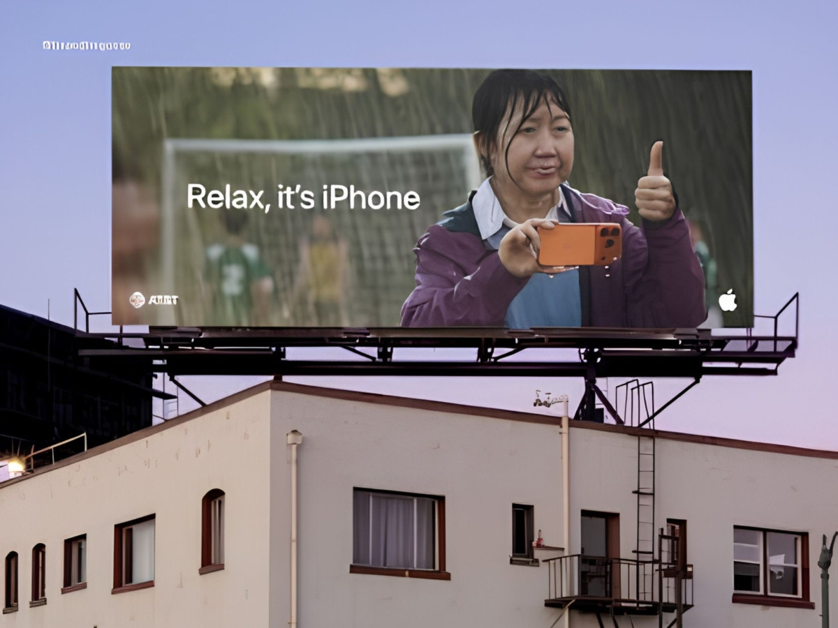 Billboard showing a woman holding an iPhone in the rain.