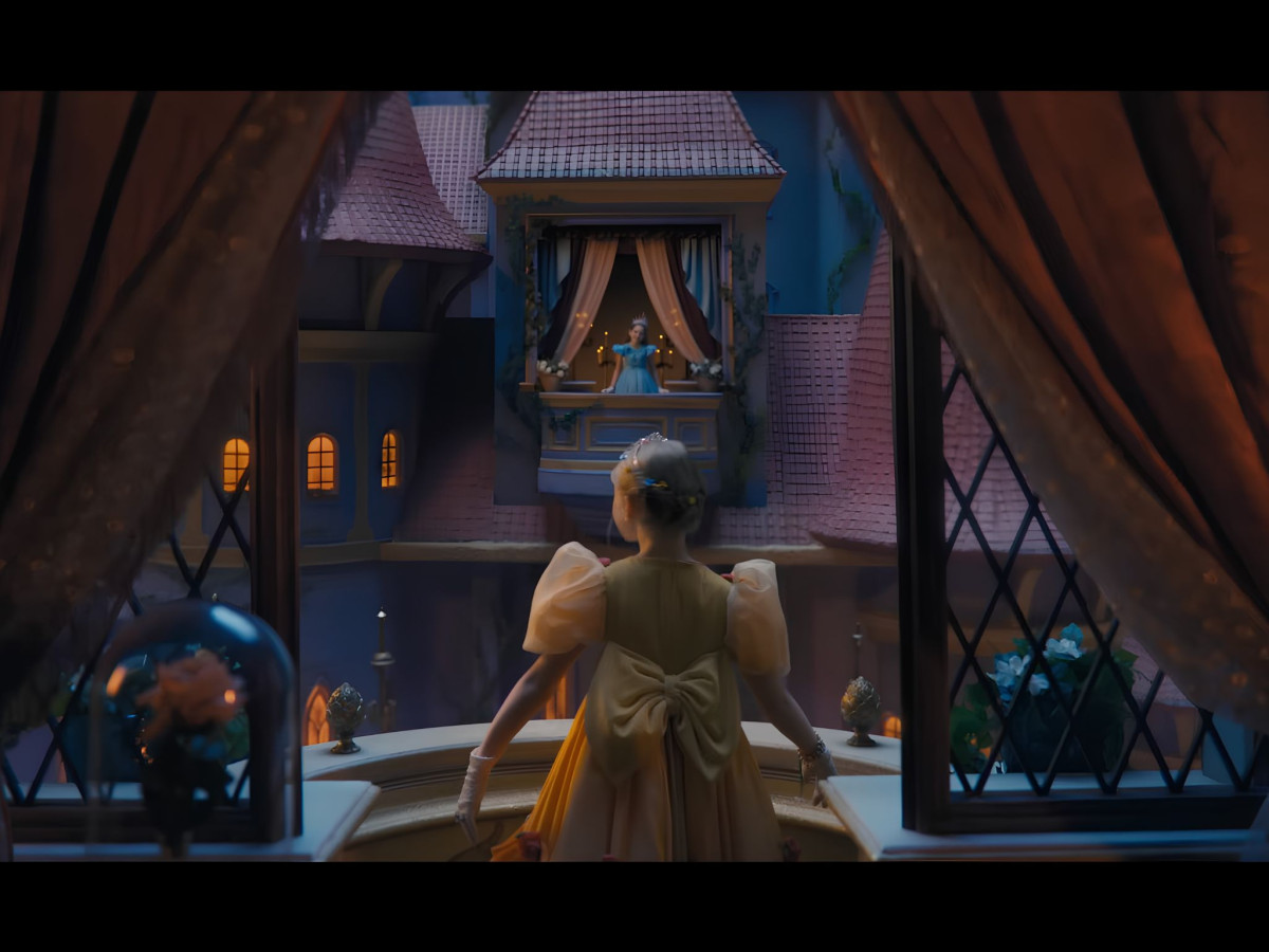 Girl in yellow dress looking at a princess balcony.