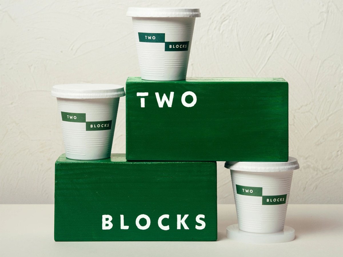 Branded white cups stacked on green wooden blocks.