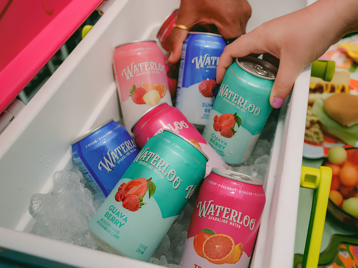 Hands grabbing colorful Waterloo cans from an ice cooler.