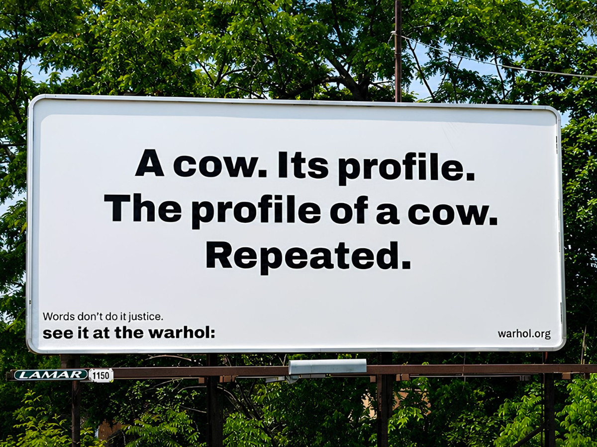White billboard reading "A cow. Its profile. The profile of a cow. Repeated."