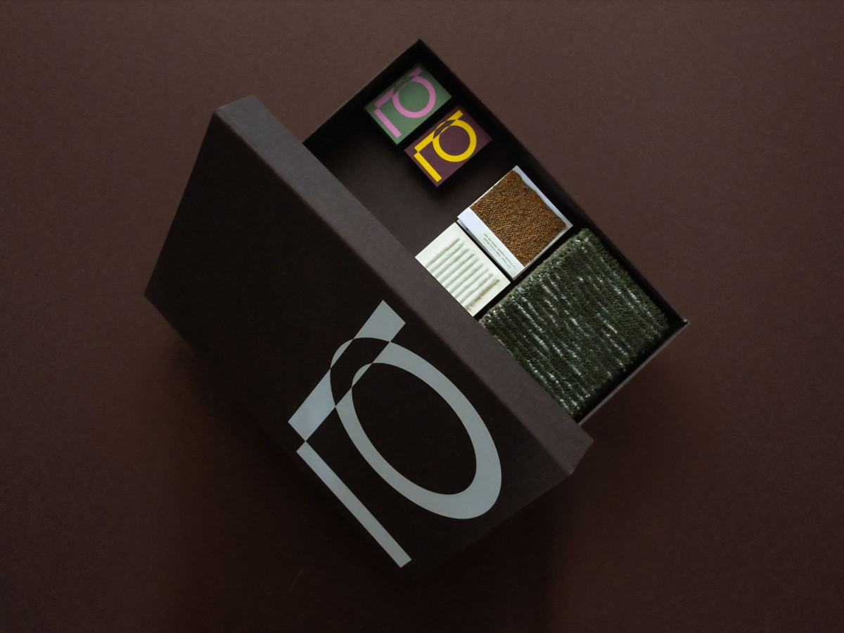 Open brown box containing fabric swatches and IO logo cards.