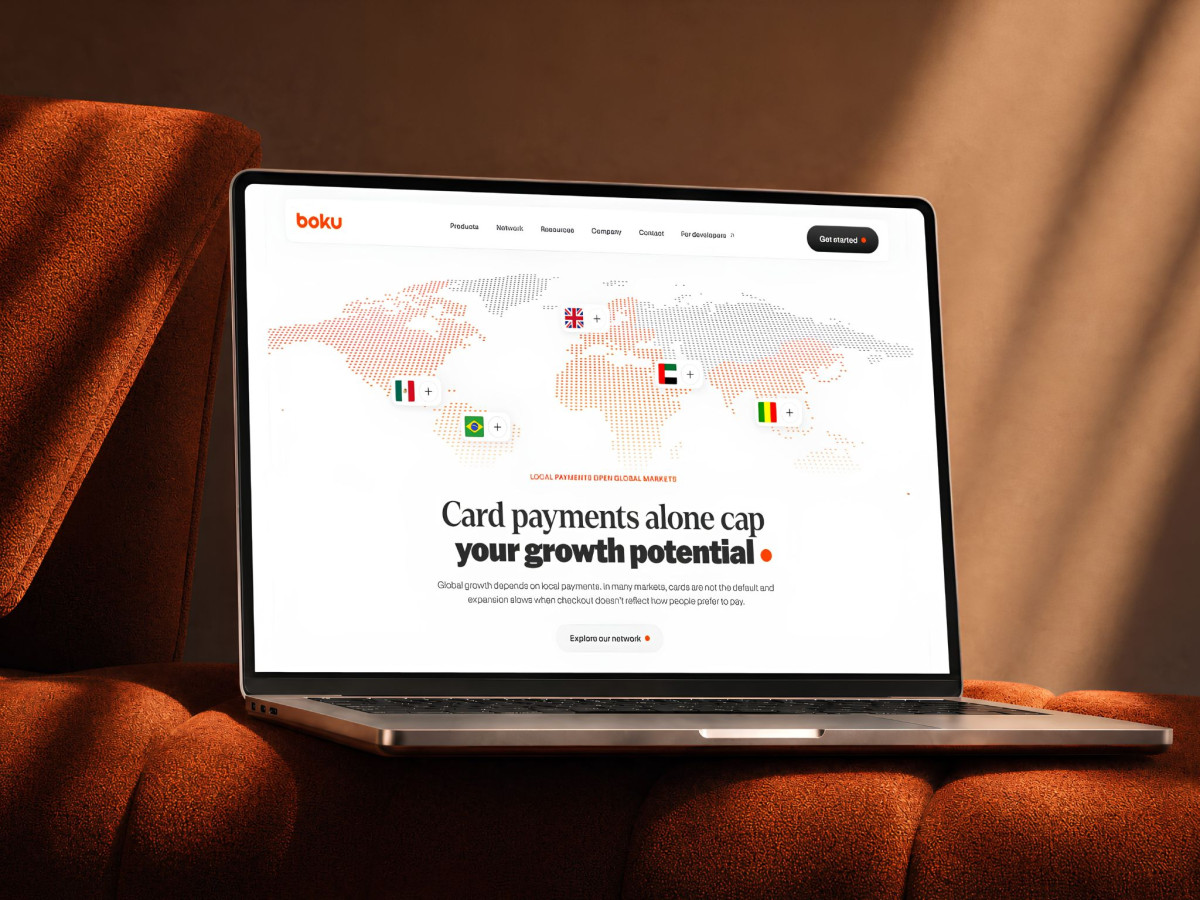 Laptop displaying the Boku website with a dotted world map and payment details.