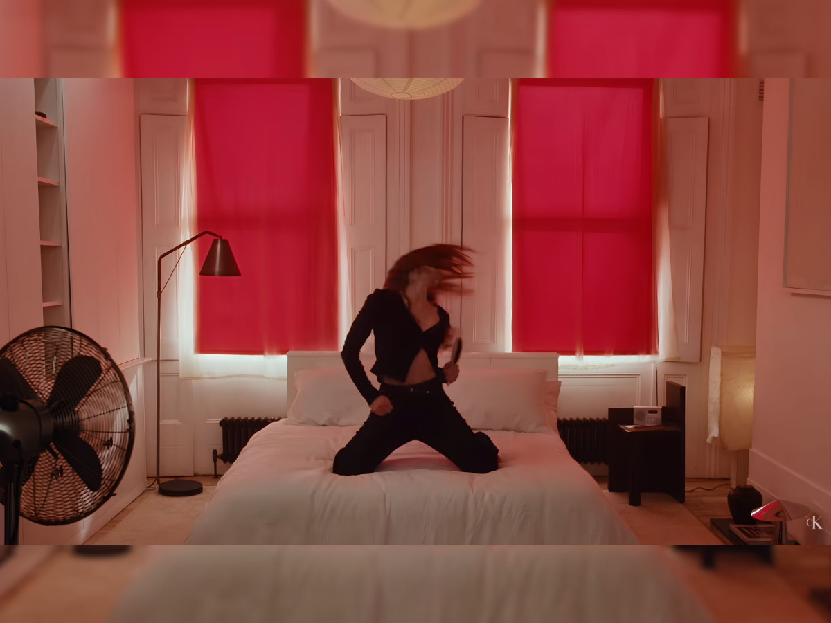 Sadie Sink posing in Calvin Klein denim dancing on the bed.