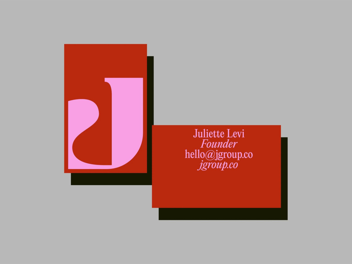 Red JGroup business cards on a gray background.