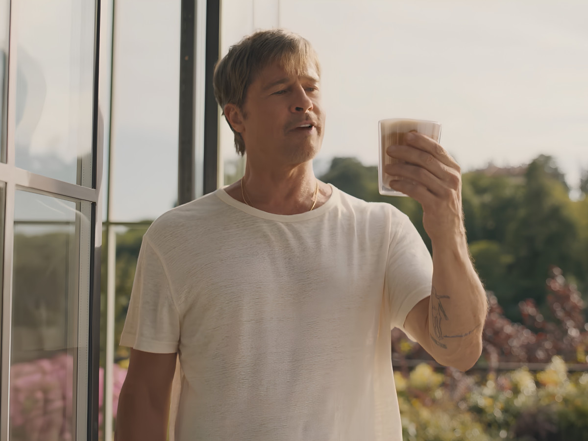 Brad Pitt holding a glass of iced coffee.