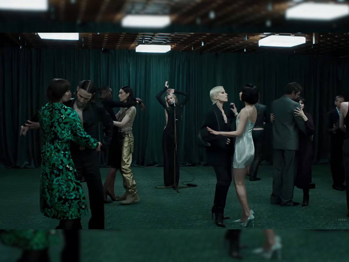 Couples dancing together in a green room.