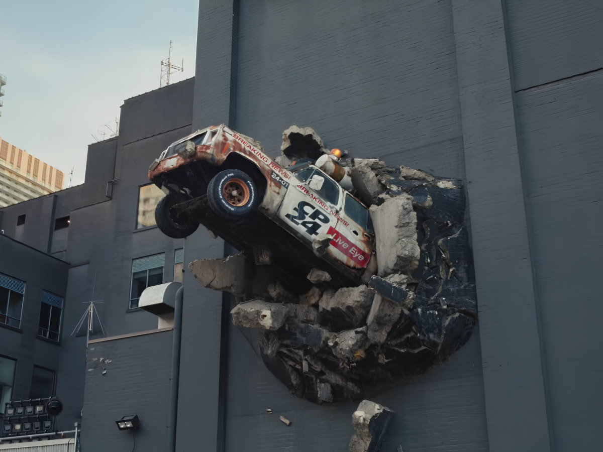 News van crashing through a building wall.