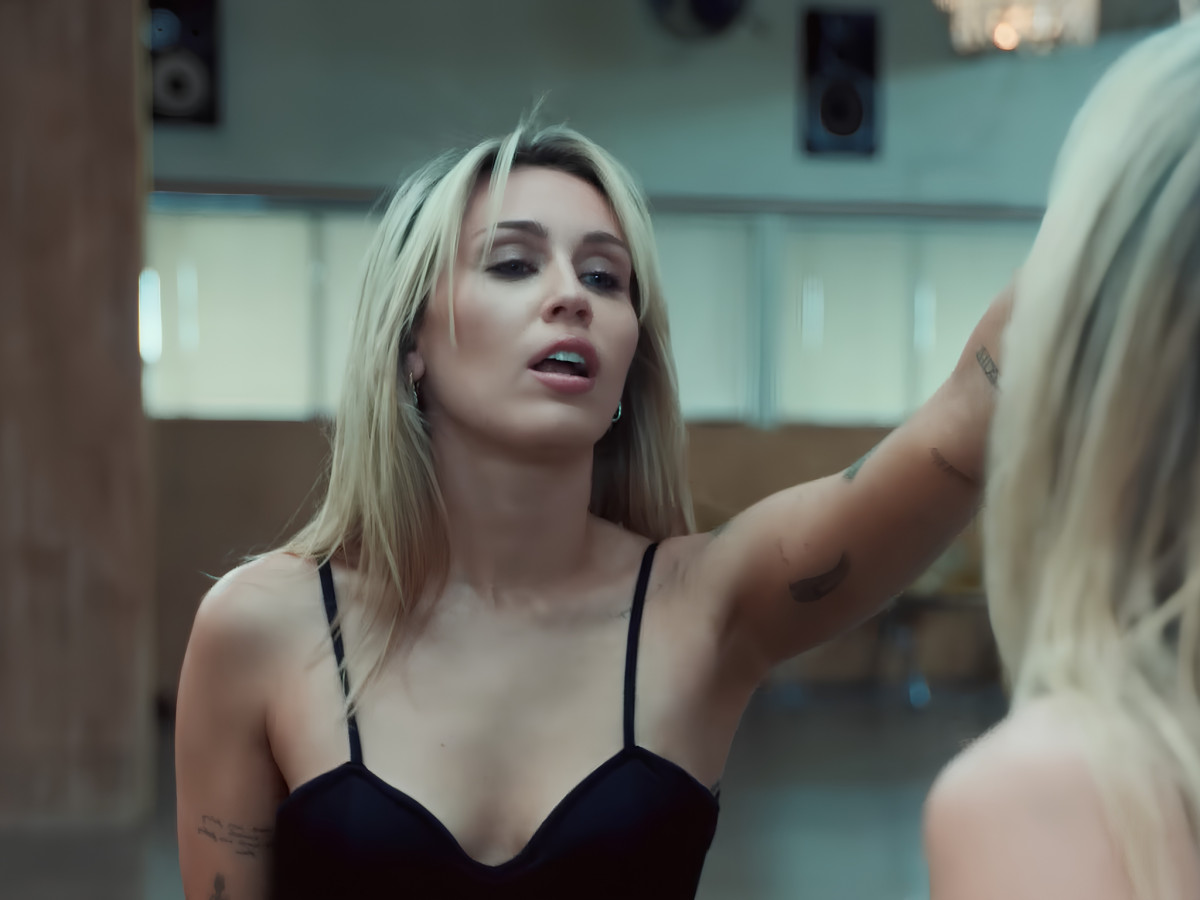 Close-up of Miley Cyrus looking into a studio mirror.