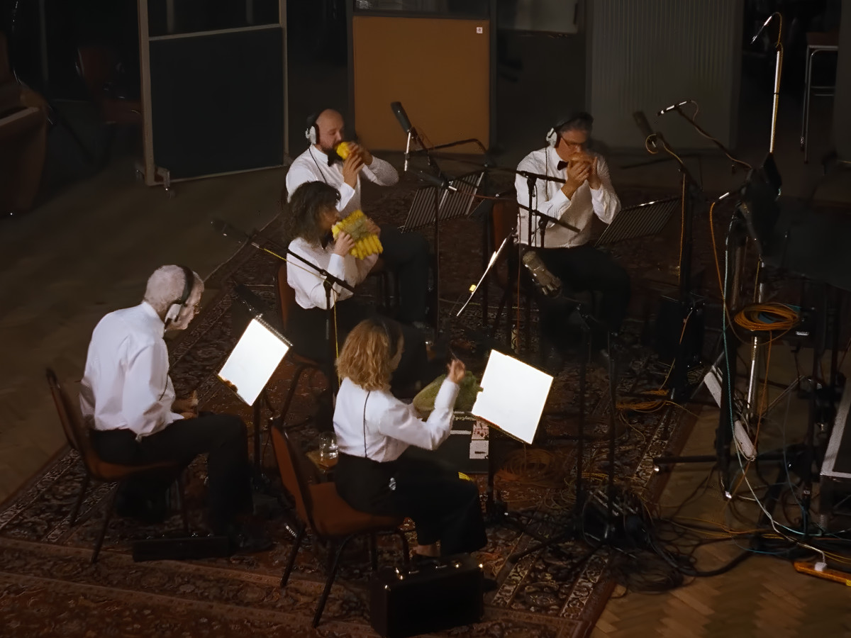 Orchestra playing vegetable instruments inside a recording studio.