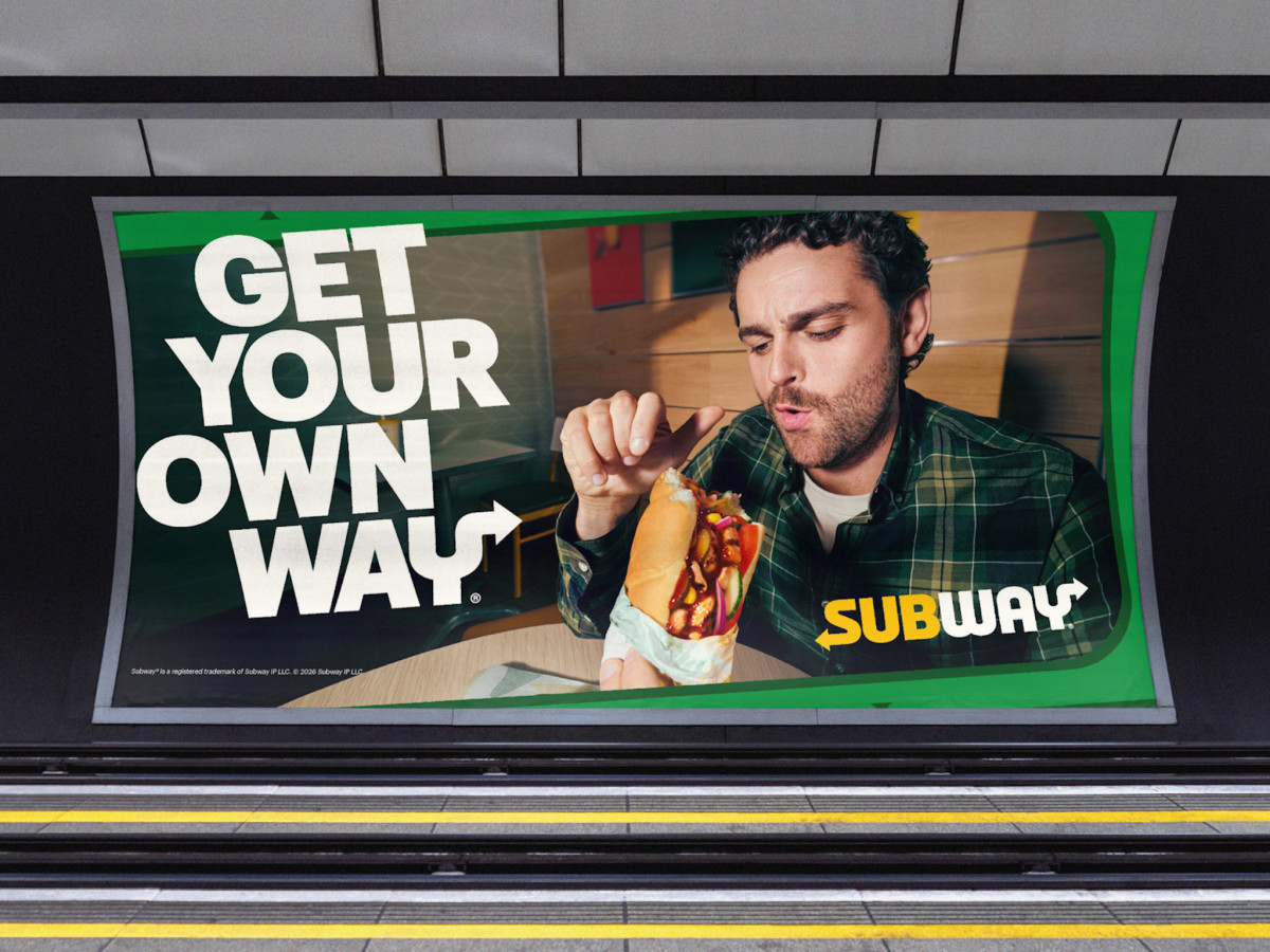 Subway billboard featuring a man eating a custom sandwich.