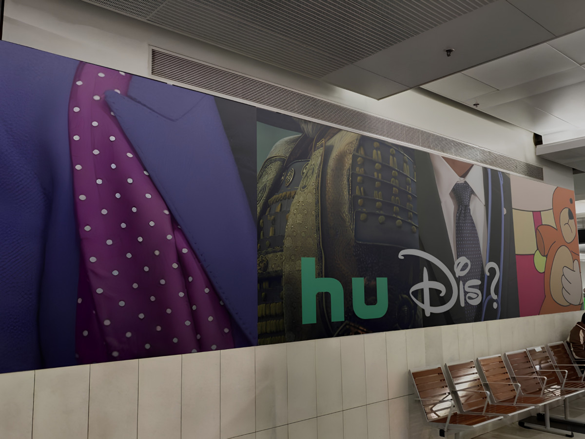 Transit wall display with cropped character costumes and "Hu Dis?" logo.
