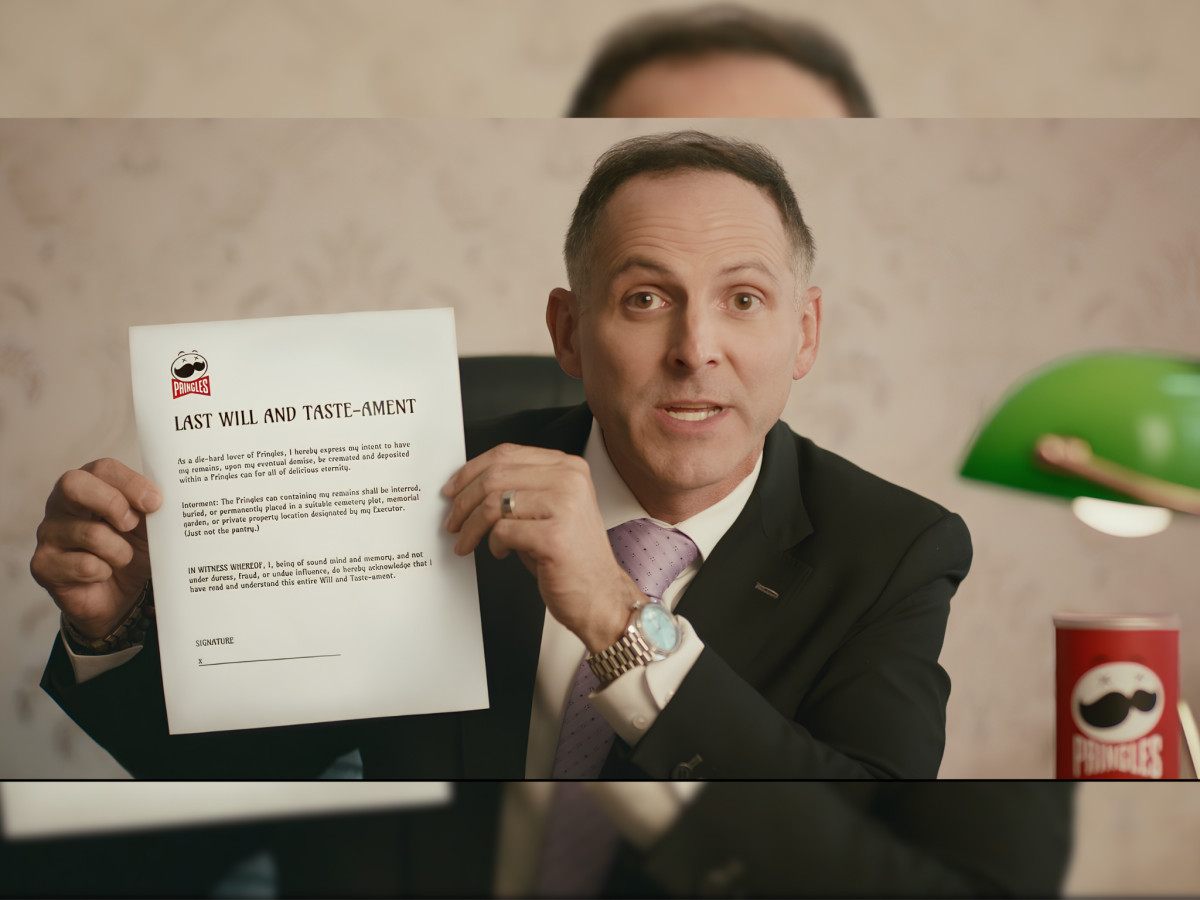 Funeral director holding a Pringles "Last Will" document.