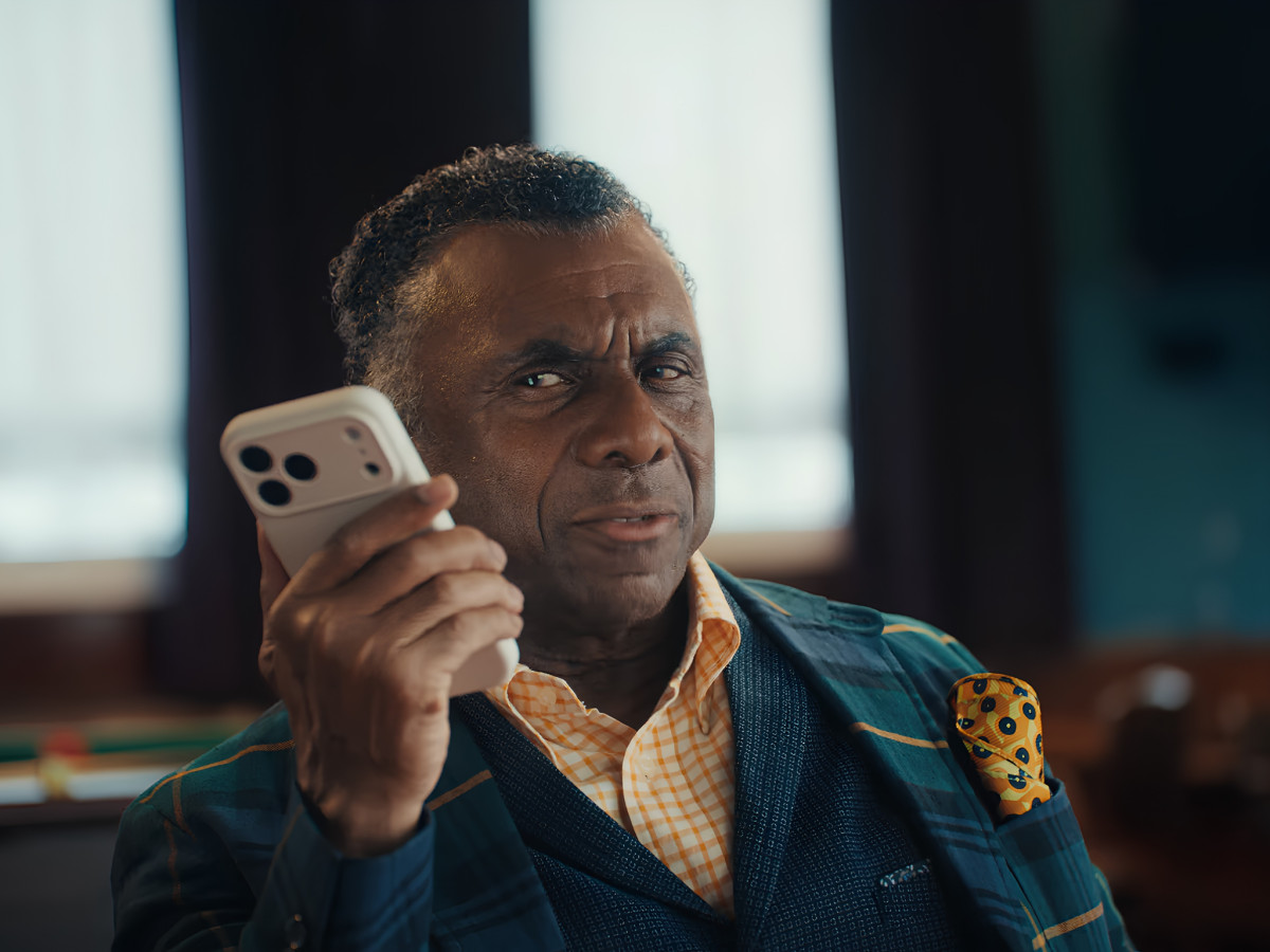 Man holding smartphone while using ChatGPT Voice feature.
