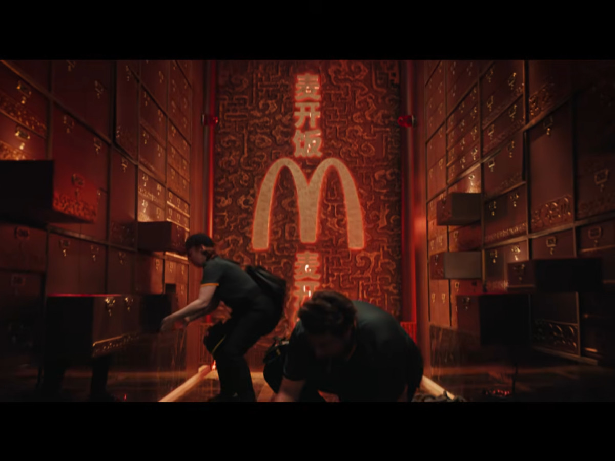 Two operatives inside vault under glowing McDonald's logo.