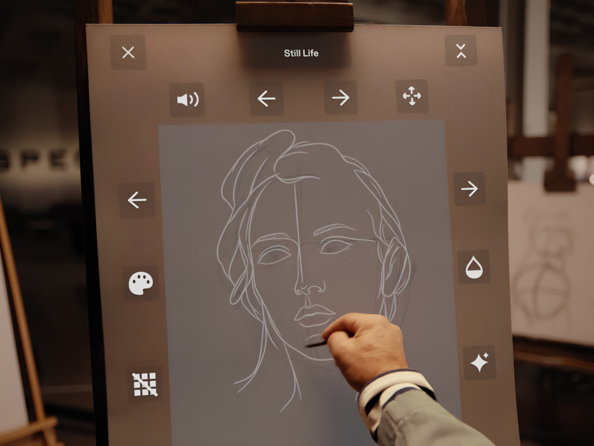 Hand sketching a portrait on canvas with digital interface.