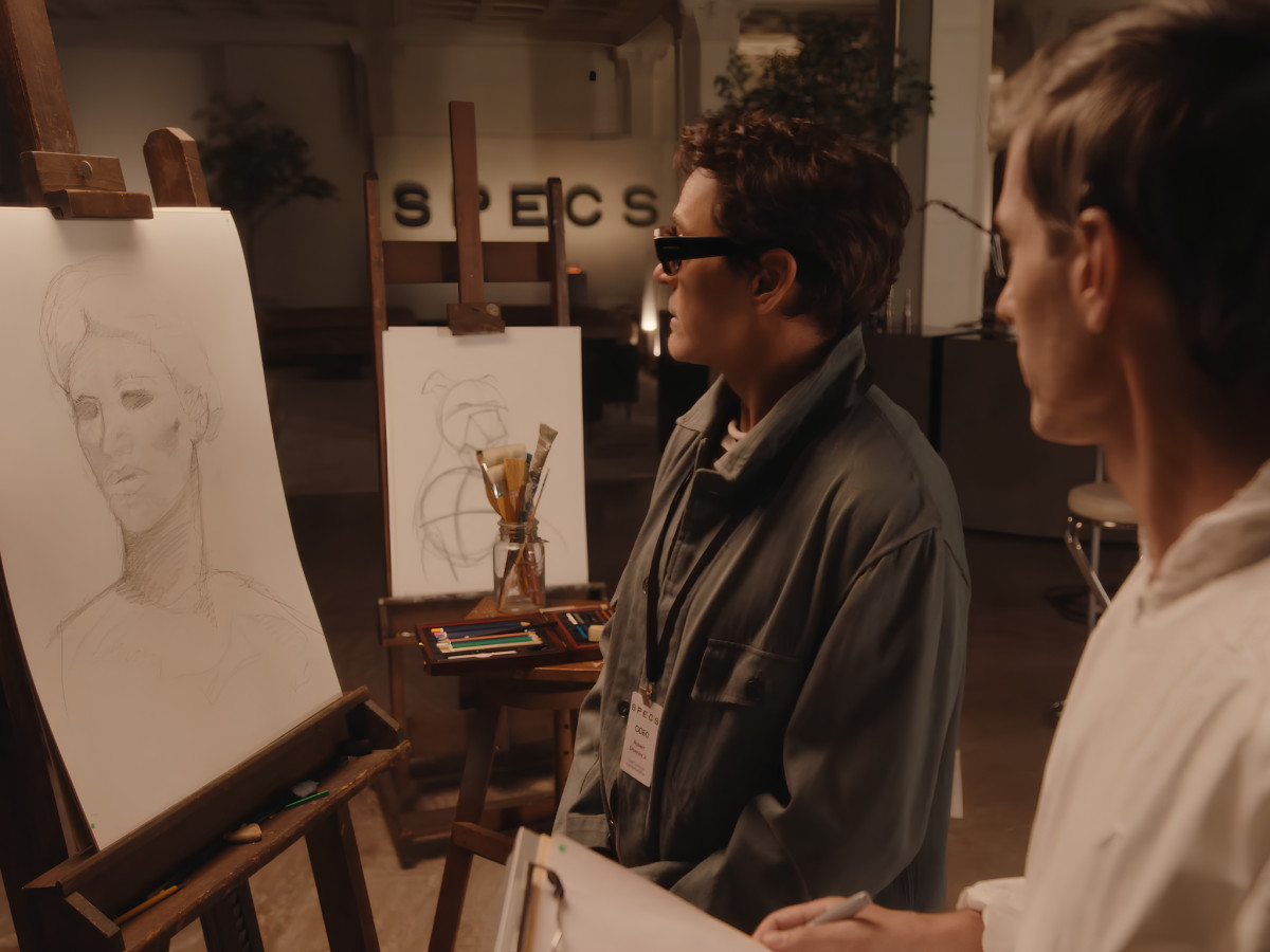 Robert Downey Jr. wearing smart glasses beside portrait easel.
