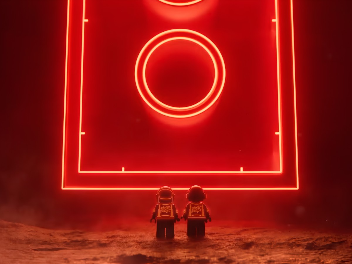 Daft Punk LEGO minifigures facing a glowing red neon structure.