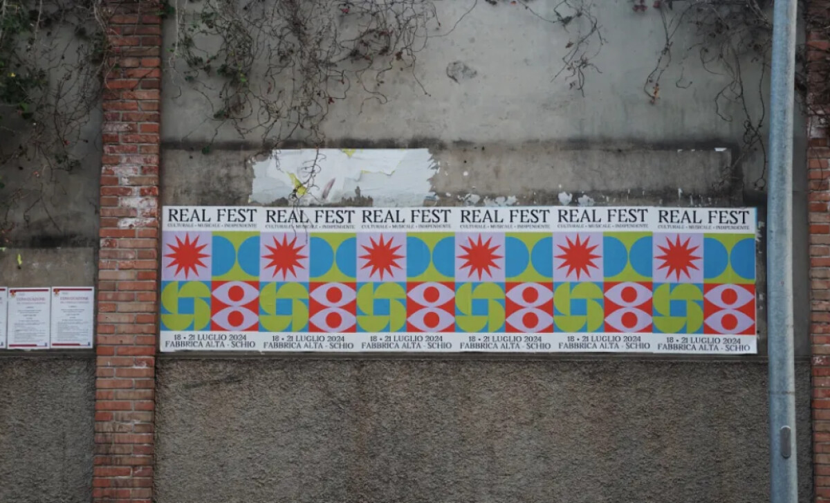 Real Fest 2024 poster displayed on an outdoor wall by Quivirgola.