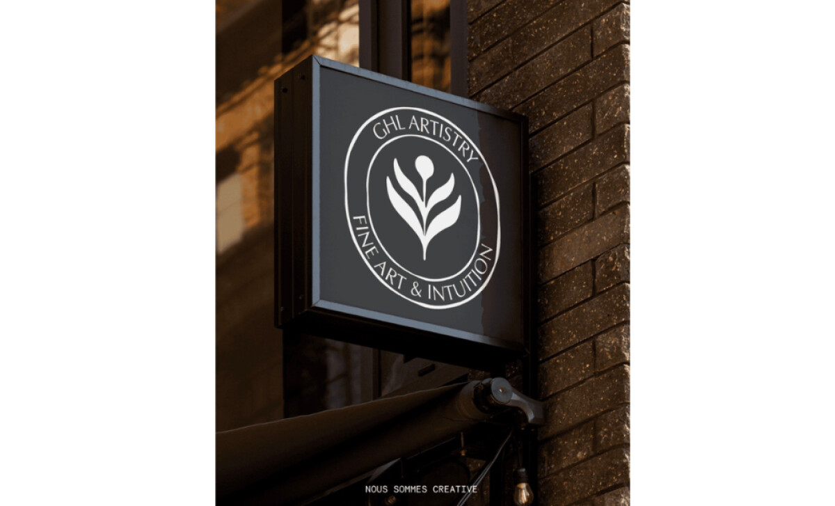 GHL Artistry round logo sign with abstract feather pen emblem