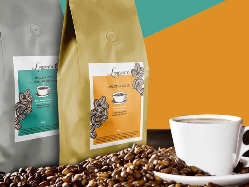 Coffee packaging of L’Incanto Miscela Gold and Miscela Dek with cup of coffee and beans.