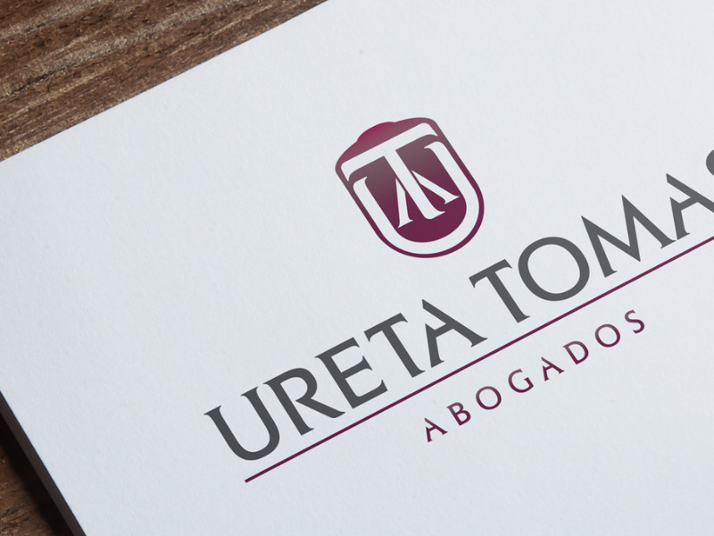 Logo design for Ureta Tomas Abogados featuring initials inside a shield by Agu Durante.