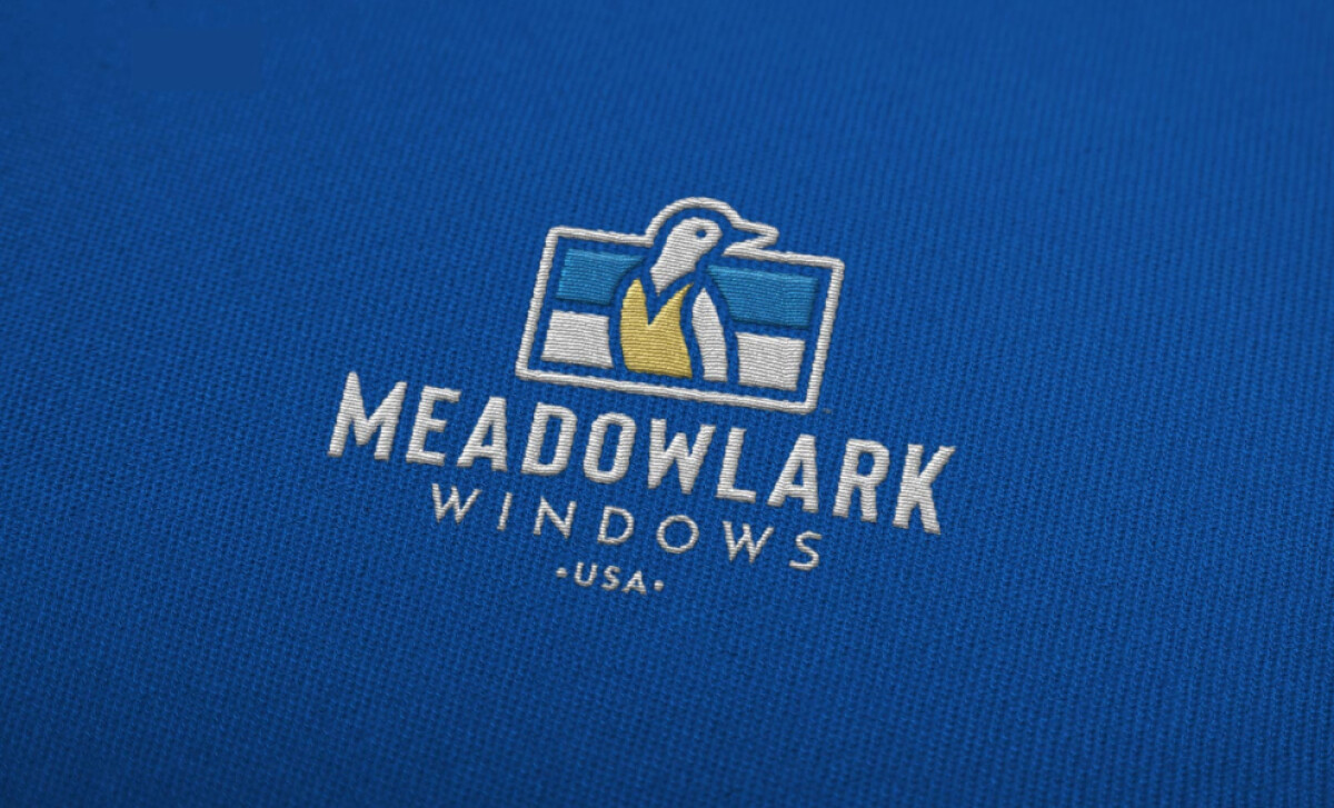Embroidered Meadowlark Windows logo on blue fabric