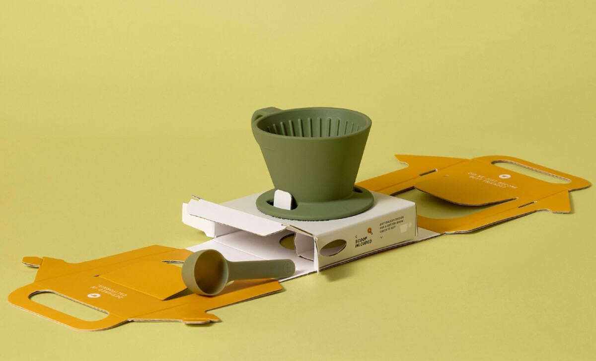 Dwell Dripper and a matching coffee scoop displayed on top of itsunfolded packaging design by Zenpack.