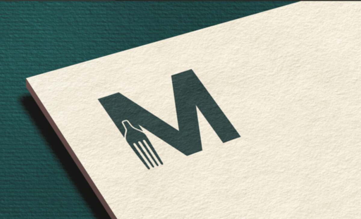 A close-up of the Mark Evans 'M' and fork monogram by OneKind Creative.