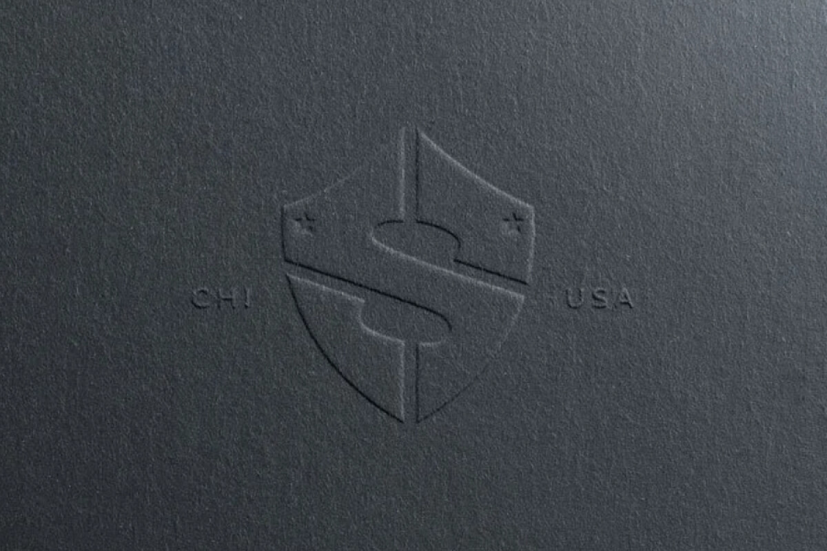 Embossed shield logo on textured paper