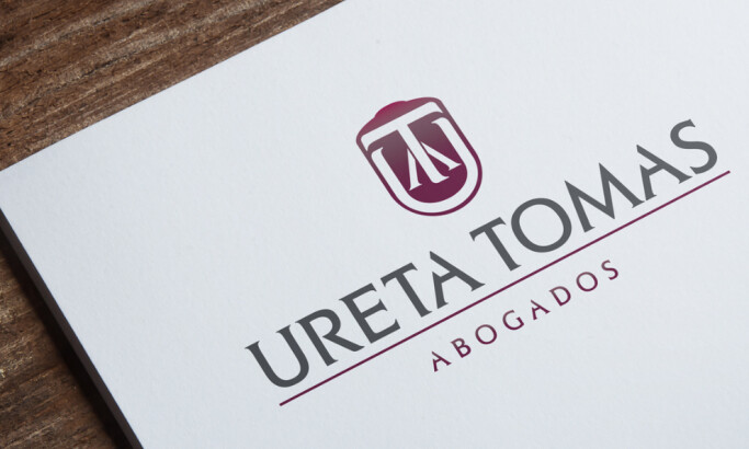 Logo design for Ureta Tomas Abogados featuring initials inside a shield by Agu Durante.