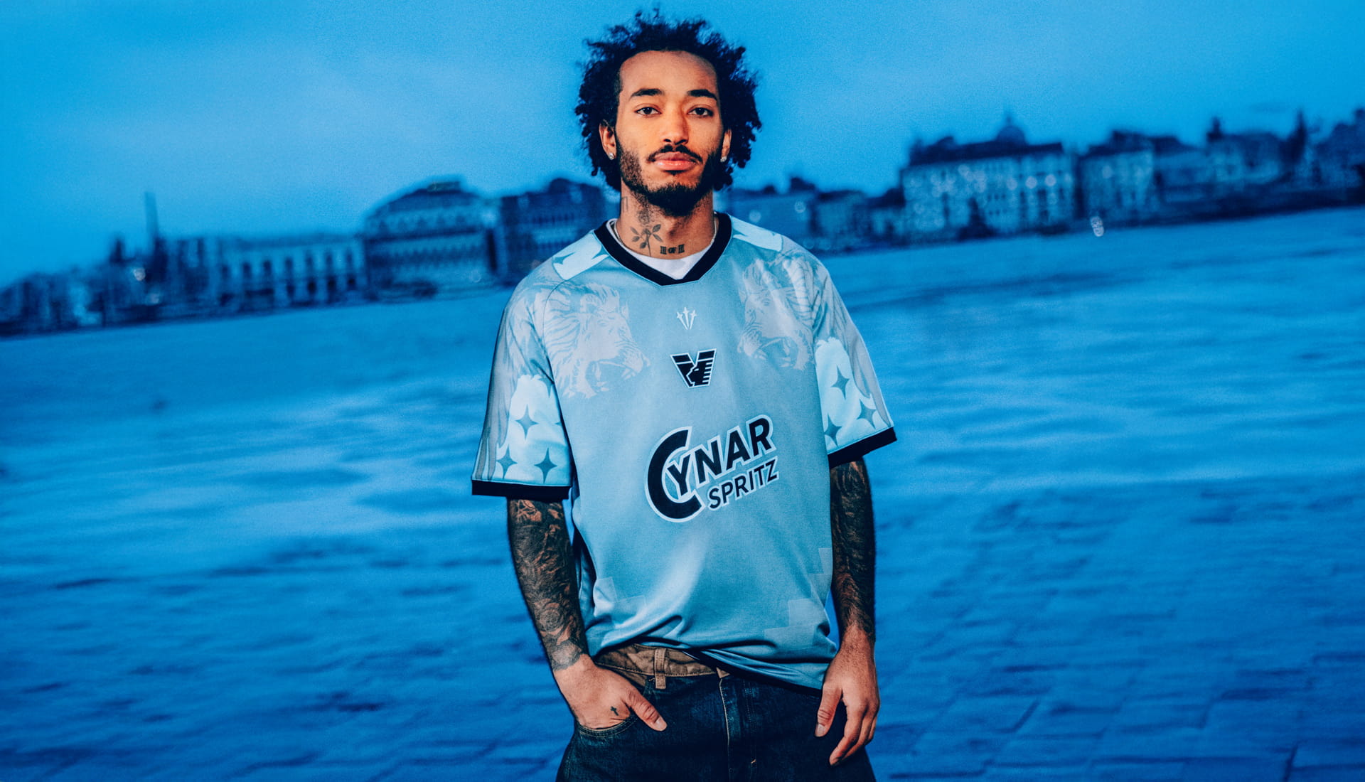 A man wearing Venezia FC Fourth Kit Jersey with Venice horizon behind him