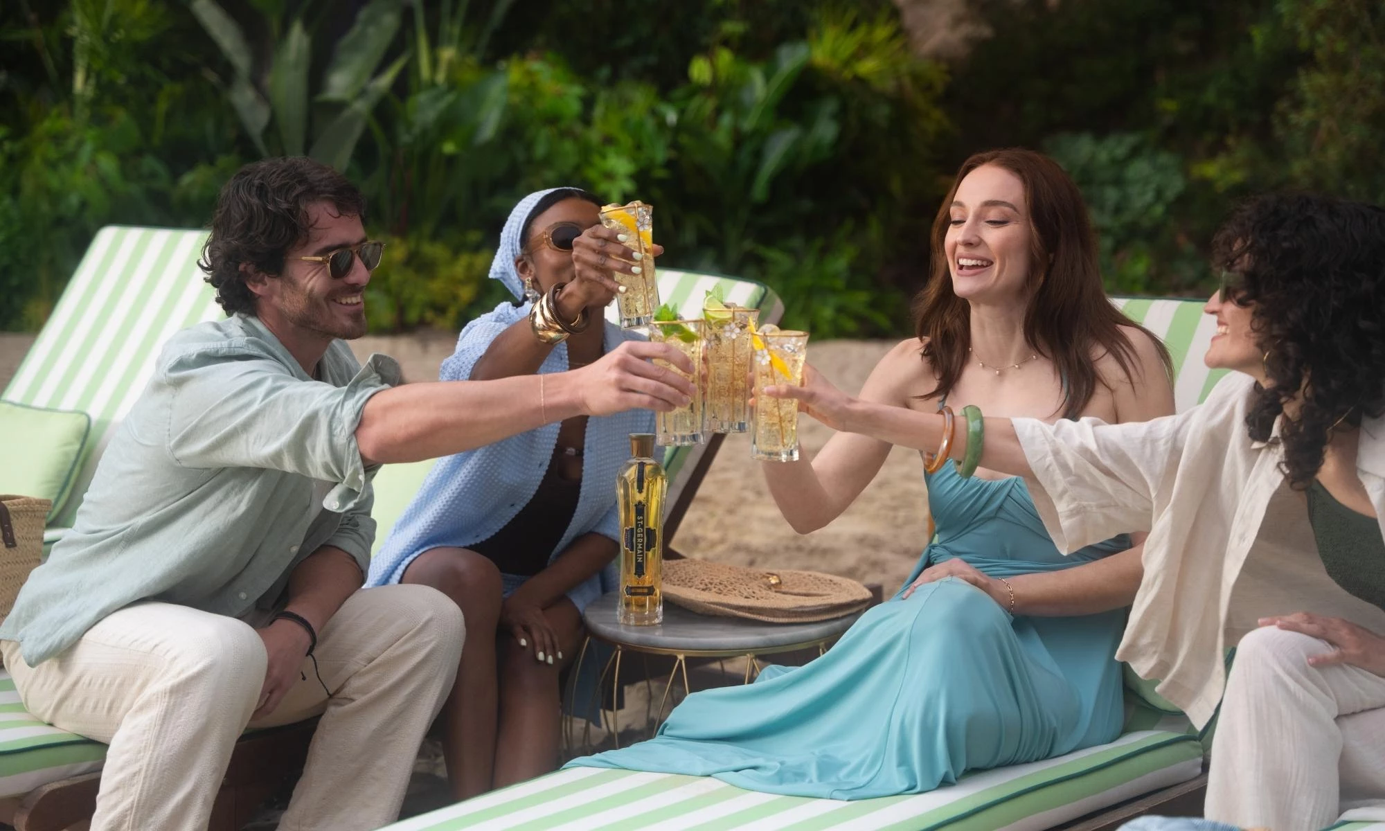 Sophie Turner with a group of friends on the beach as they cheers St-Germain drinks
