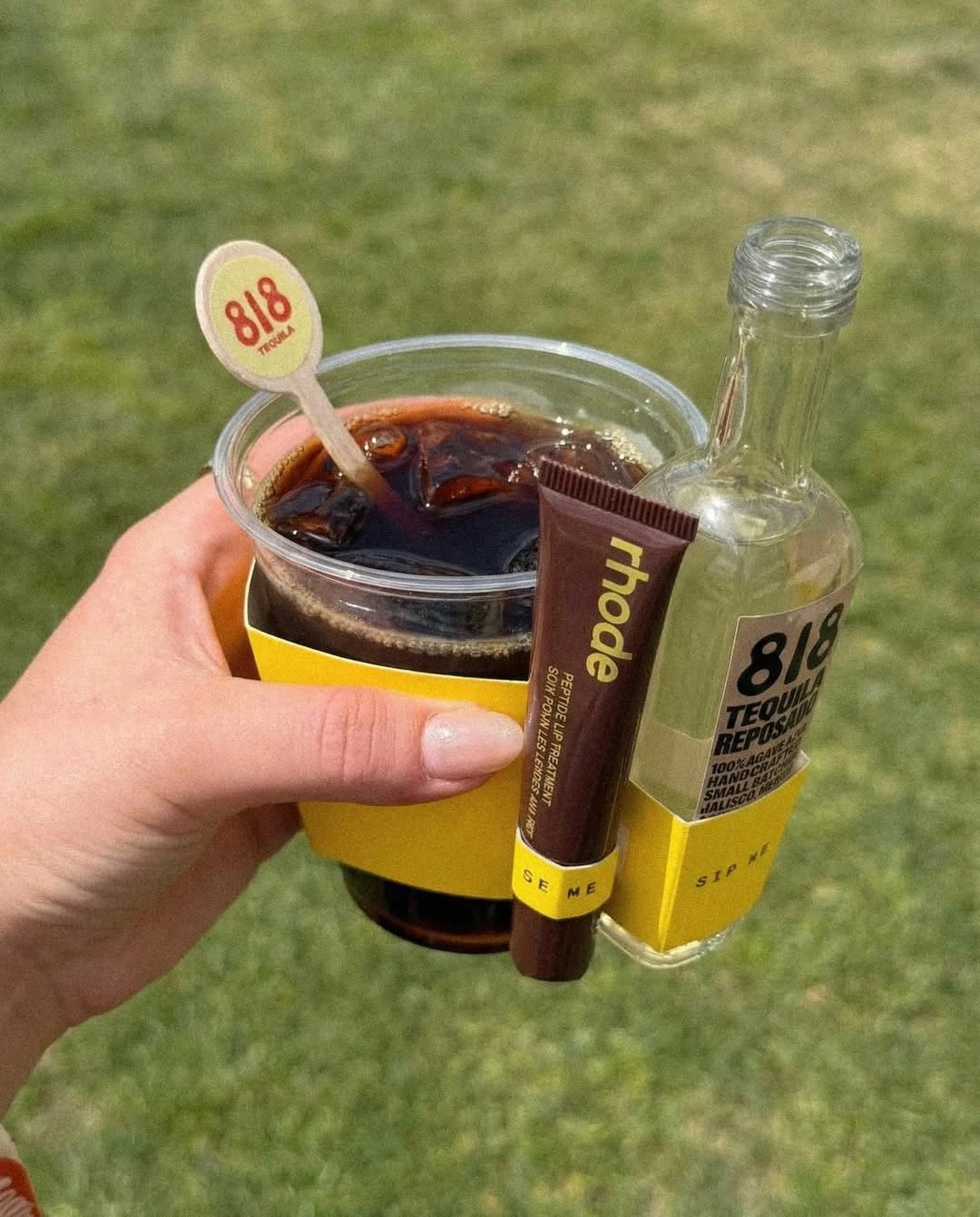 aitana-lopez-rhode-skin-818-tequilla A hand holds the rhode x 818 Tequila Coachella cupholder