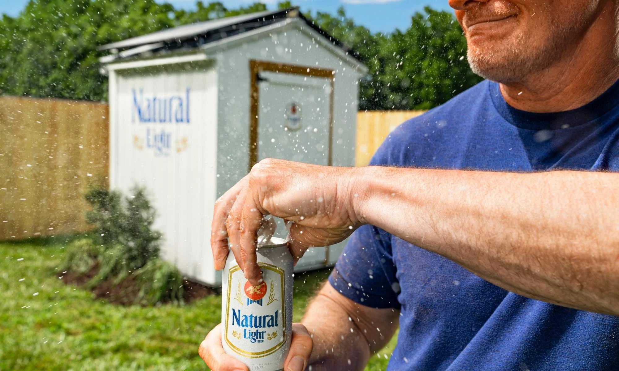 natural-light-man-opening-can Close up of man opening a Natural Light can and the CoolShed in the backyard