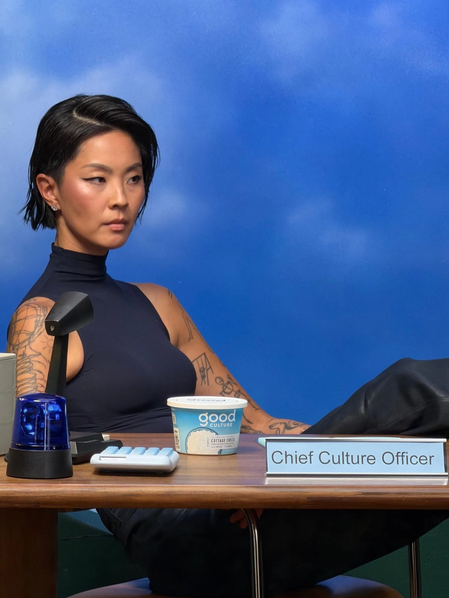 Kristen Kish poses at a desk with a tub of Good Culture and a "Chief Culture Officer" plaque.