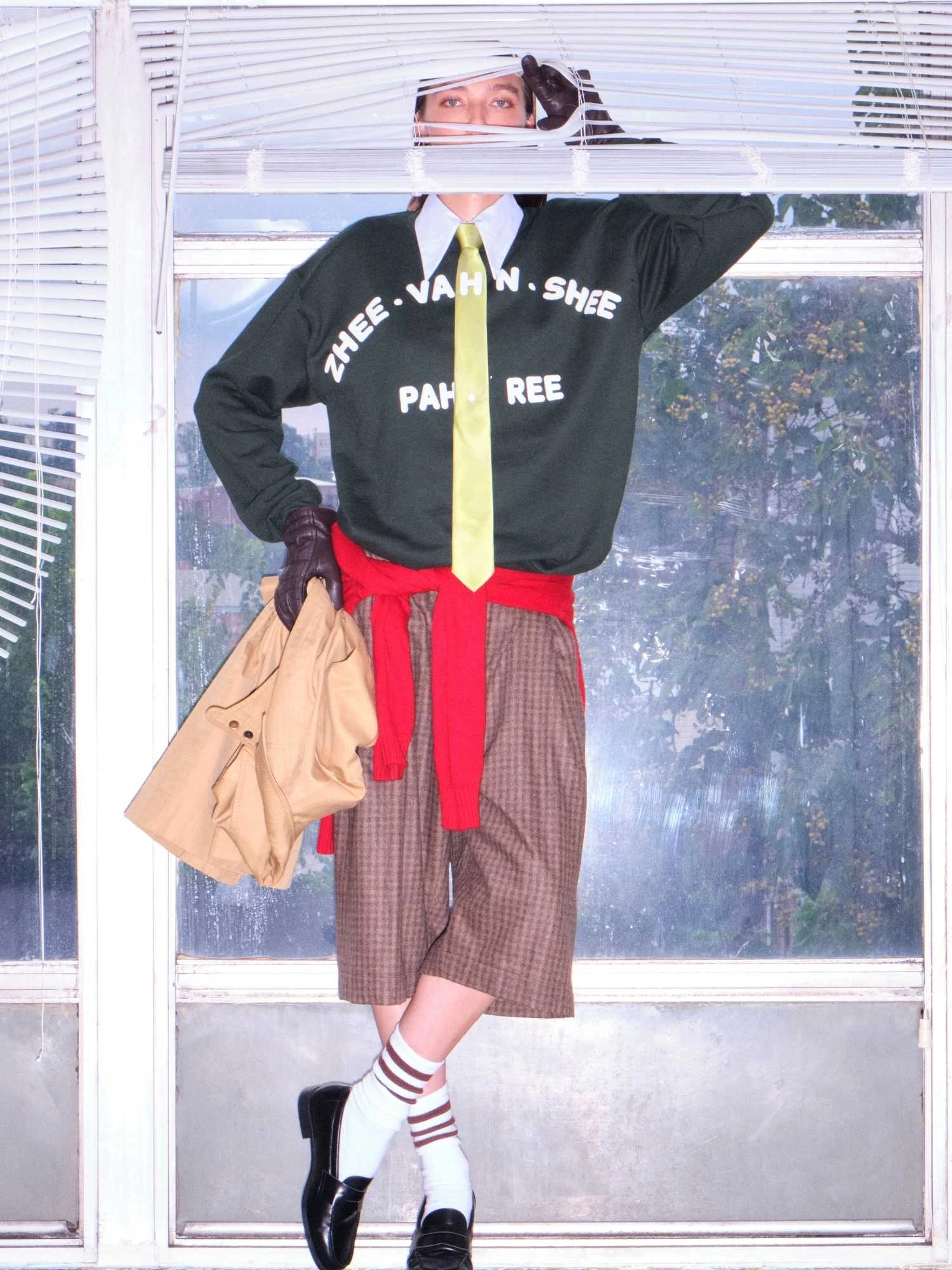 duolingo-givenchy Model wearing Duolingo's ZHEE-VAHN-SHEE PAH-REE outfit posing with window blinds.