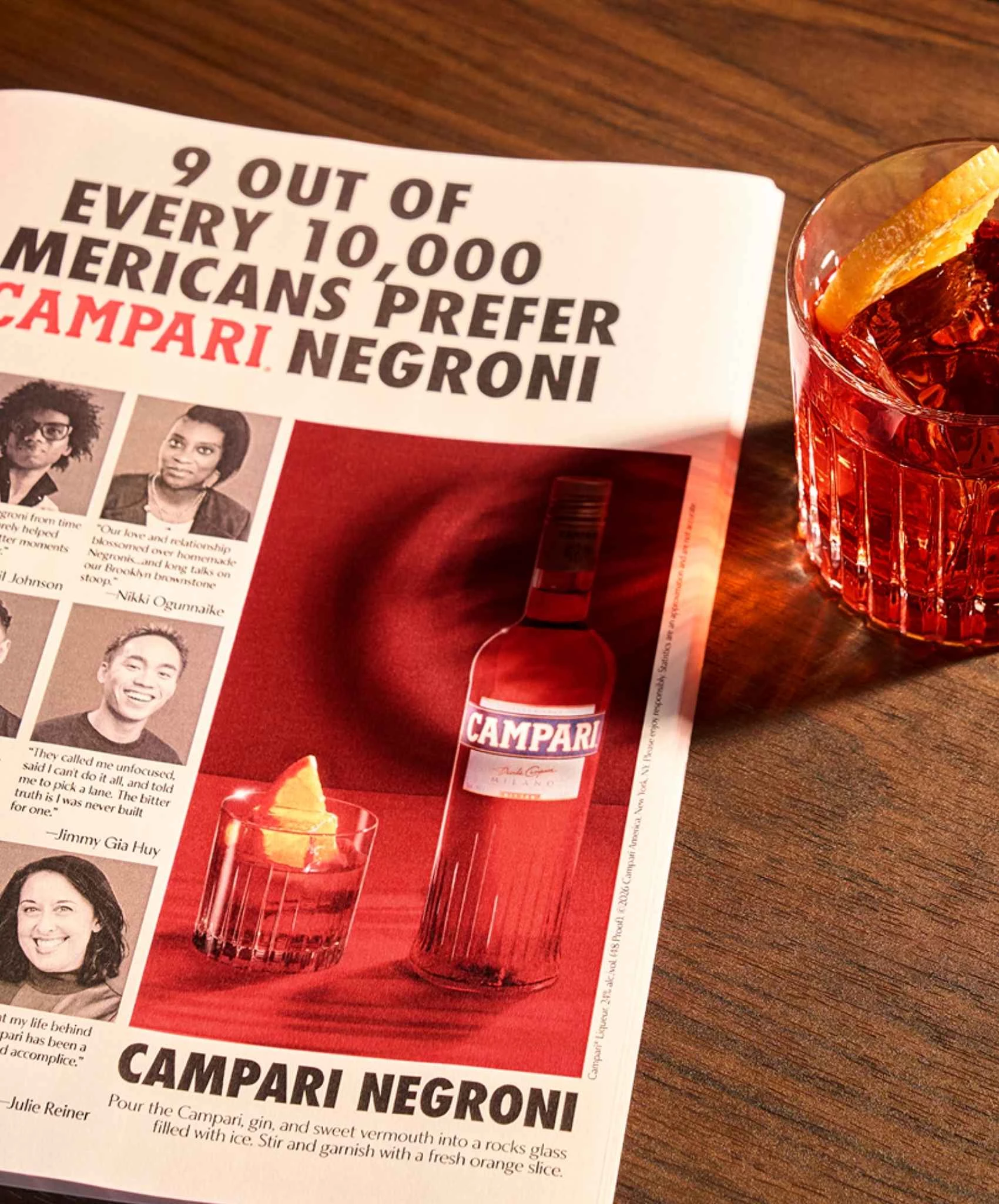 A newspaper placed next to a Campari Negroni