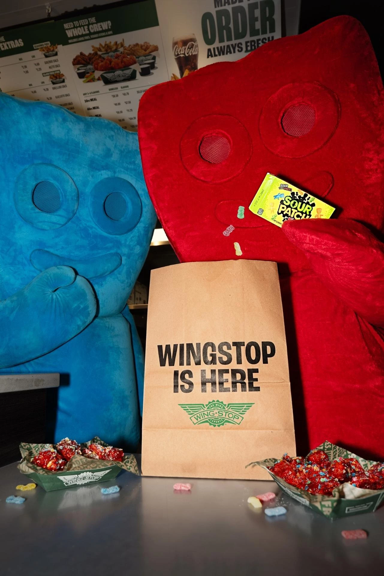 SOUR PATCH KIDS mascots with a Wingstop takeout bag.