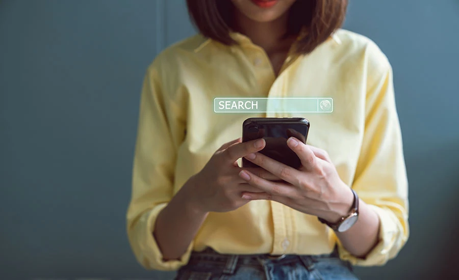 magento-seo-guide Woman searching for products on Google on her smartphone