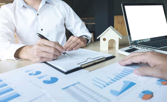 Man signing documents with charts about real estate