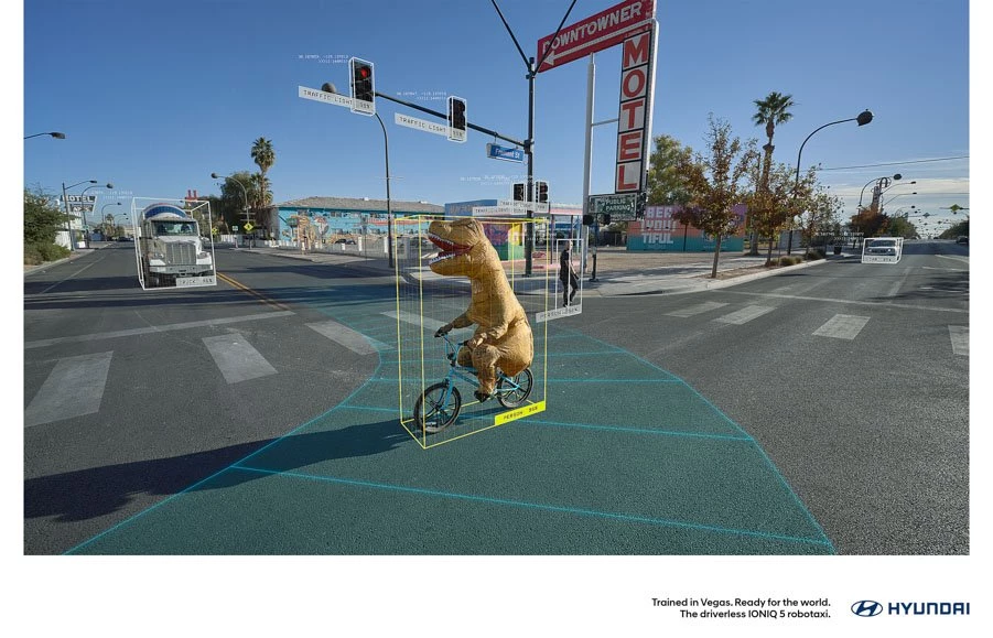 A person in a T-Rex costume crosses a Vegas street.
