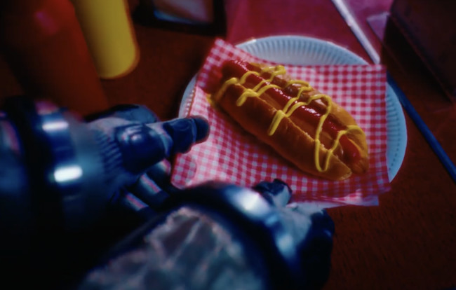 A cosplayer enjoys a hotdog at the tavern. 