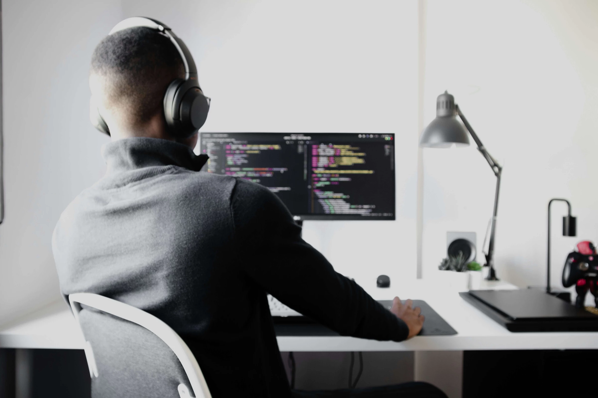 Person coding on a computer, illustrating what is backend development in a professional 