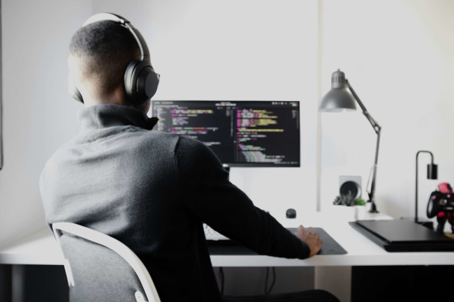 Person coding on a computer, illustrating what is backend development in a professional 