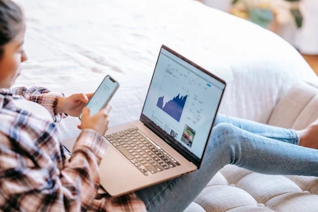 person-using-smartphone-with-laptop Person using smartphone with laptop