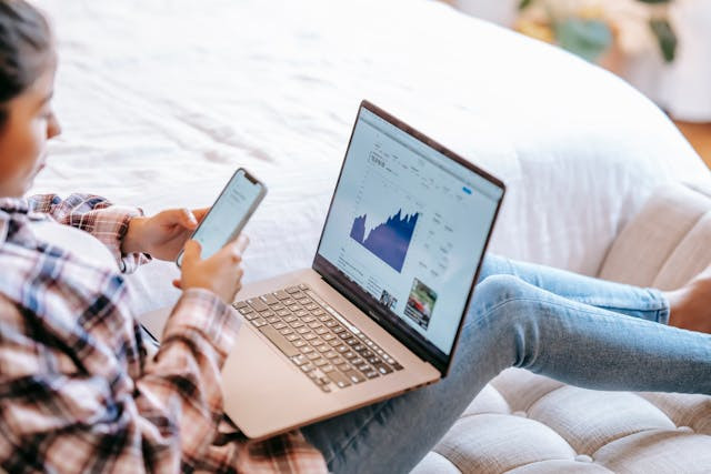 person-using-smartphone-with-laptop Person using smartphone with laptop